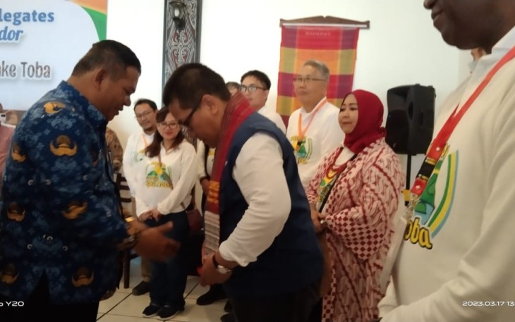 Asisten II Pemkab Samosir Hotraja Sitanggang memberikan Syal Ulos kepada delegasi
