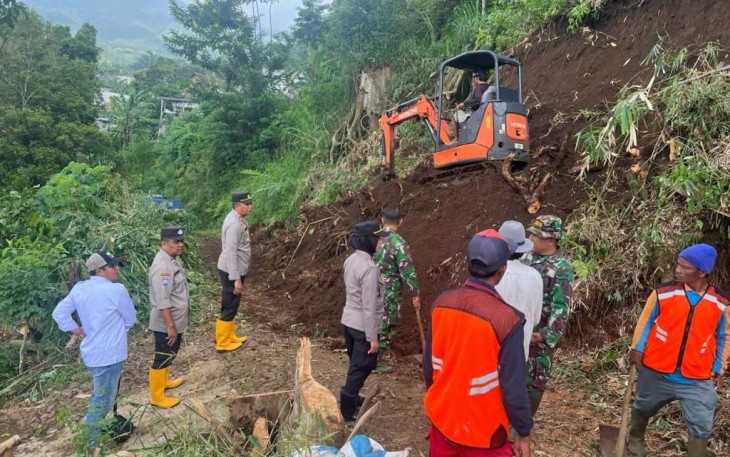Evakuasi material tanah longsor menggunakan alat berat di jalan penghubung desa Dailsodo Kecamatan Wagir, Malang, Rabu (28/2)
