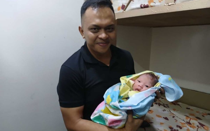 Letda Laut (K) dr Riezqi Bakrie menggedong bayi pasca persalinan 