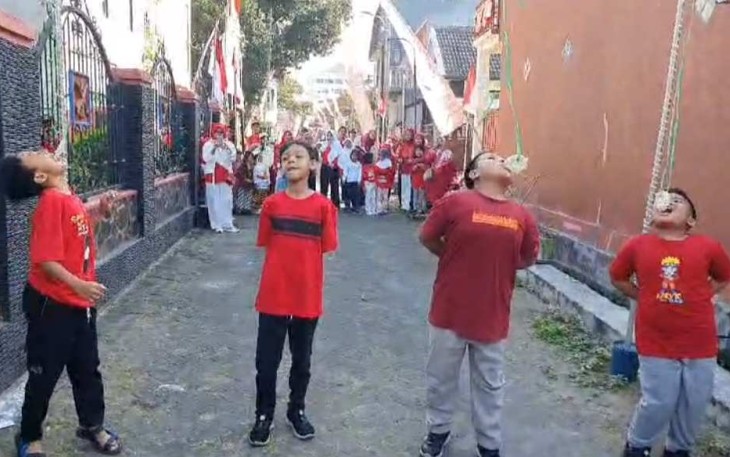 Lomba makan kerupuk anak-anak di jalan Joyo Utomo Gang IX, Kelurahan Merjosari, Minggu (25/8)