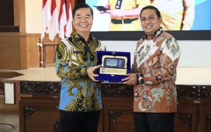 Dirjen Dukcapil Teguh Setyabudi memberikan cenderamata 