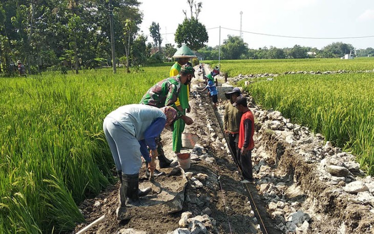 Babinsa saat Muneng Bantu Warga Bangun Saluran Irigasi, Minggu (21/1/2024).