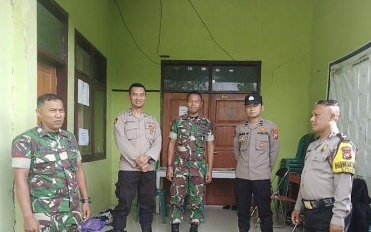 Anggota Koramil 01/Ngawi bersama personil Polsek Ngawi Kota saat melaksanakan pengamanan kotak suara pemilu di Kantor Kecamatan Ngawi, Kabupaten Ngawi, Minggu (18/02/2024).
