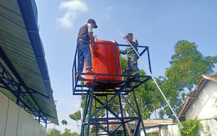 Babinsa Koramil Madiun saat Bantu Pembuatan Tandon Air di Desa Binaannya