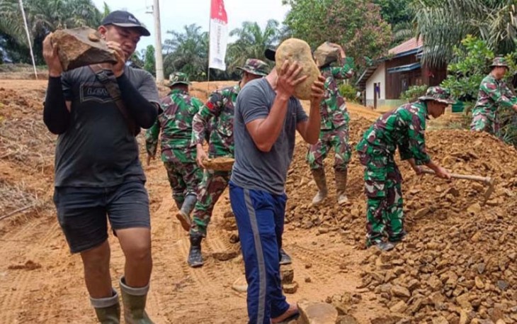 Bongkahan batu besar dan material batu pecah disusun dan diratakan untuk pengerasan jalan 1,8 Km. Satgas TMMD dan masyarakat gotong royong merapikan badan jalan dengan lebar 5 meter.