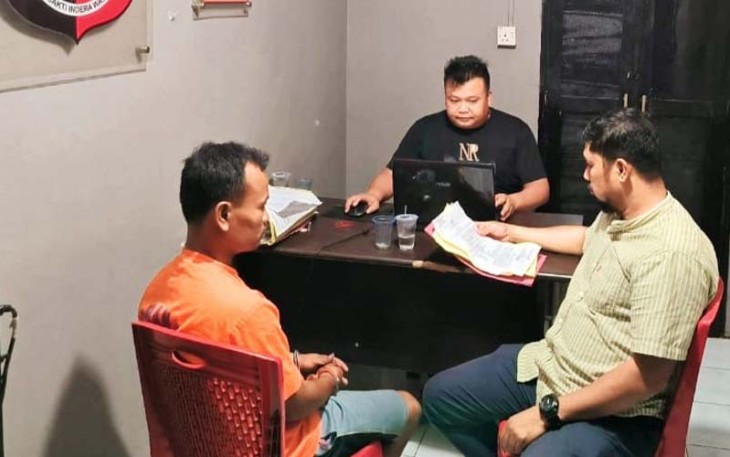 Tersangka diborgol (kiri) saat diperiksa penyidik
