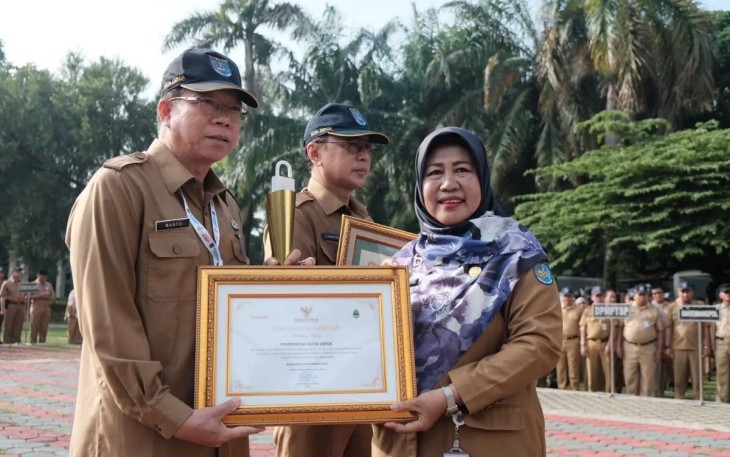 Pj. Sekda Depok, Nina Suzana menyerahkan piagam penghargaan kepada Kepala Dinas Komunikasi dan Informatika (Diskominfo) Kota Depok, Manto pada Apel Pagi, Senin (18/11/24