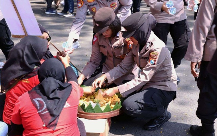 Polwan Polresta Malang Kota saat memberikan makanan