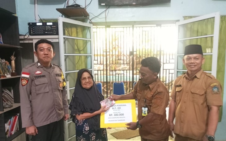 Bhabinkamtibmas saat Dampingi Pembagian BLT Dana Desa Secara Tunai
