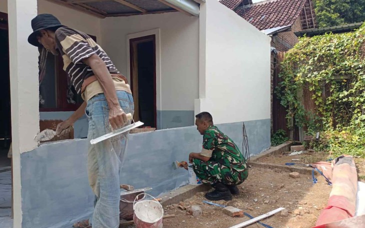 Bantu mengecat rumah warga desa binaan