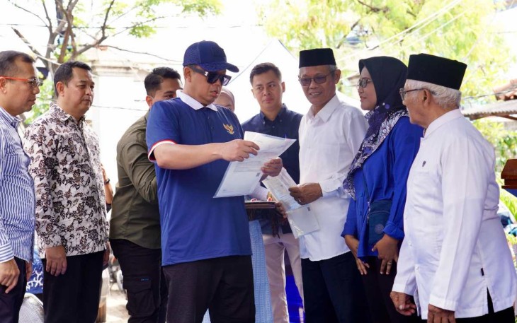 Menteri Nusron saat menyerahkan sertifikat HGB di kampung nelayan Muara Angke, Jakarta, Minggu (16/2)