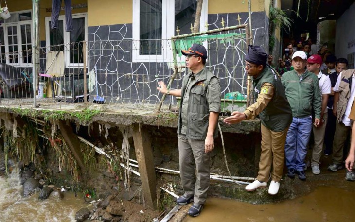 Kepala BNPB Letjen TNI Dr. Suharyanto S.Sos., M.M., (topi rompi hijau) saat meninjau lokasi jembatan yang amblas terdampak banjir bandang di Desa Tugu Selatan, Kecamatan Cisarua, Kabupaten Bogor, Jawa Barat, Senin (3/3).