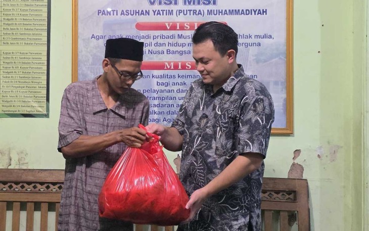 Setiawan AD 1 PM saat menyerahkan ikan segar ke pengasuh panti asuhan putra Muhammadiyah Wonogiri, Minggu (6/4)