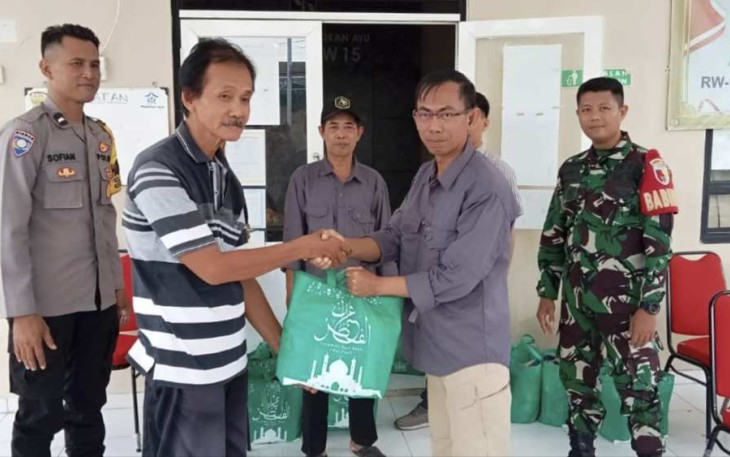 Michael Markus Ketua RW 15 Kelurahan Medokan Ayu menyerahkan paket sembako, Kamis (27/3)
