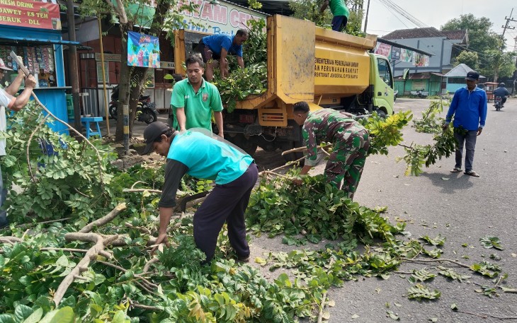 Babinsa Koramil 01/Ngawi Bersama Petugas Tebangi Pohon di Pinggiran Jalan Raya