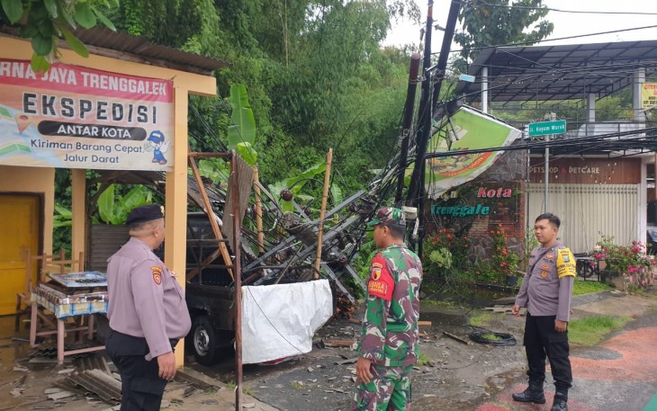 Babinsa Koramil 0806-01/Trenggalek, Serka Suprianto, bersama Bhabinkamtibmas dan BPBD Trenggalek dibantu warga sekitar langsung bergerak cepat mengevakuasi pohon yang tumbang.