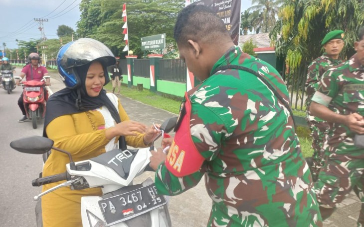 Anggota Koramil Timika Bagikan Bendera Merah Putih Bagi Pengguna Jalan