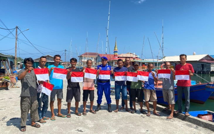 Nelayan Perbatasan saat terima bendera merah putih dari Satpolairud Polres Natuna.