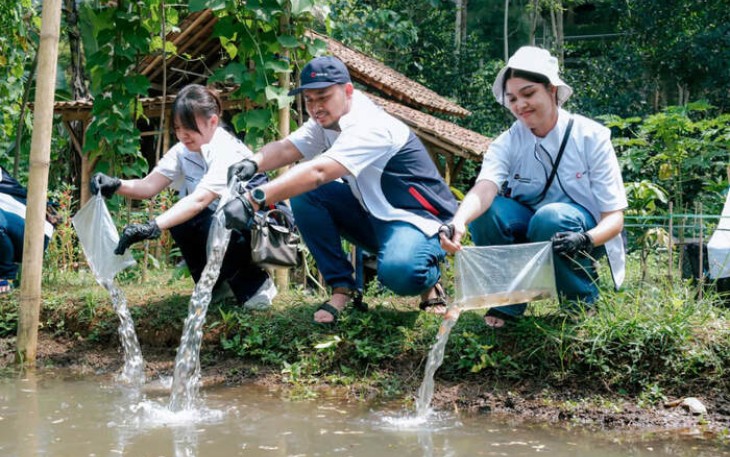 Penebaran Benih Ikan di Kolam pada Program Sosial Senyawa Employee Volunteer Volume 3, MIND ID di Desa Ciderum