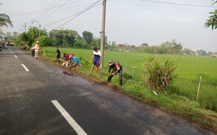 Babinsa Desa Gandul Bersama Masyarakat Laksanakan Kerja Bakti Pembersihan Jalan