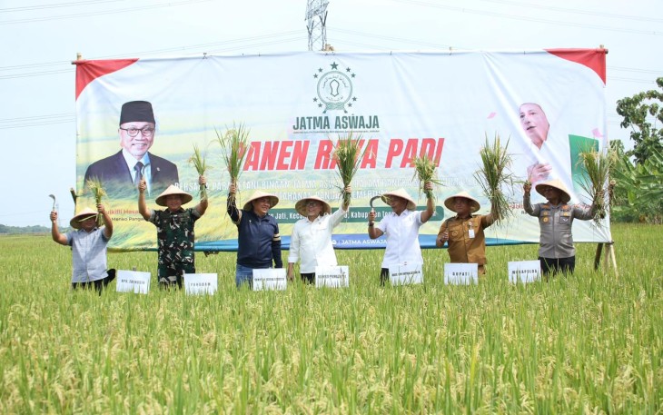 Sekretaris Jenderal JATMA ASWAJA, Helmy Faishal Zaini (ketiga kari kiri) bersama Menteri Koordinator Pangan RI, Zulkifli Hasan (keempat dari kiri) melakukan proses potong padi sebagai bentuk kesyukuran panen raya petani binaan JATMA ASWAJA di Tegal