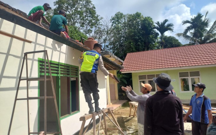 Bhabinkamtibmas Polsek Belitang III Laksanakan Gotong Royong Renovasi Aula Balai Desa
