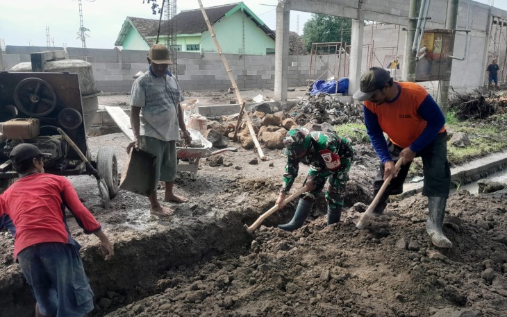Babinsa dan Warga Tulungrejo saat Gotong Royong Perbaiki Talut di Halaman Koperasi Desa