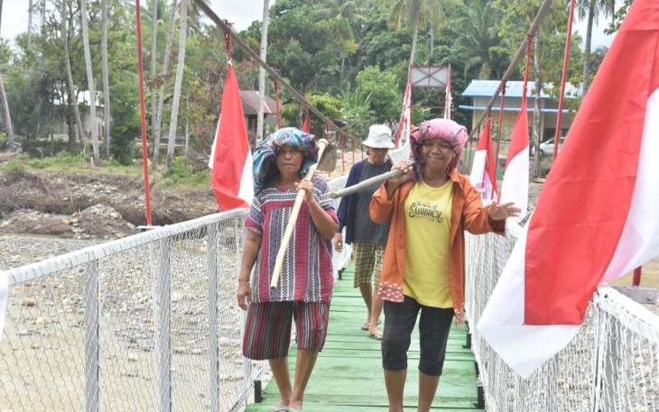 Warga desa Mudik saat melintasi di jembatan perintis Garuda, Senin (16/3)