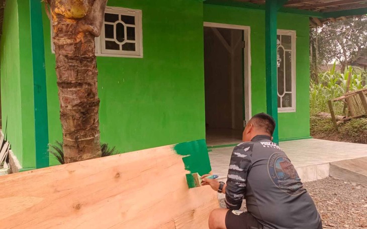 Pengecatan pintu RTLH ibu Sumana