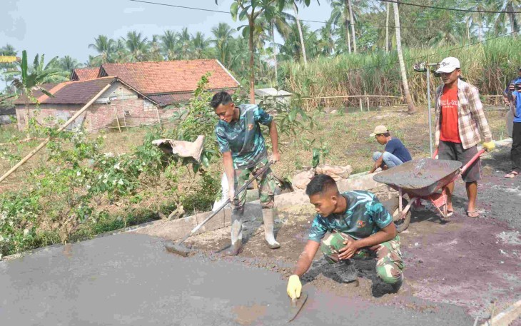 Prada Aditya Rohman Rapikan Permukaan Rabat Beton TMMD