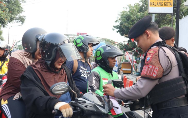 Pemberian bendera merah putih di depan mako Polresta Malang Kota, Minggu (16/8)