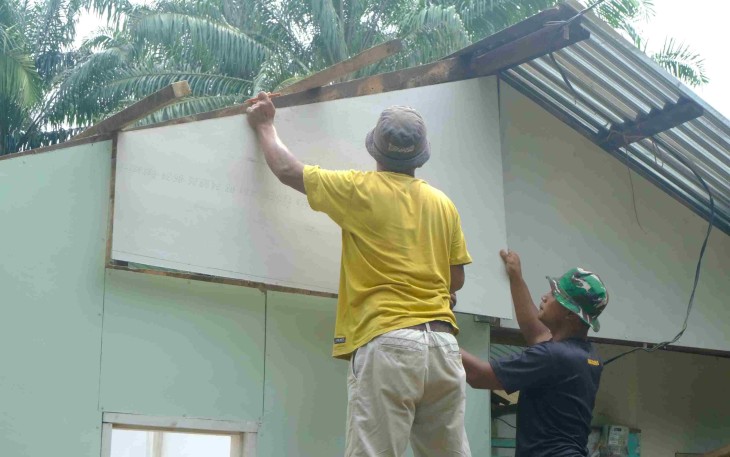 Pemasangan dinding rumah Tukirin Desa Aek