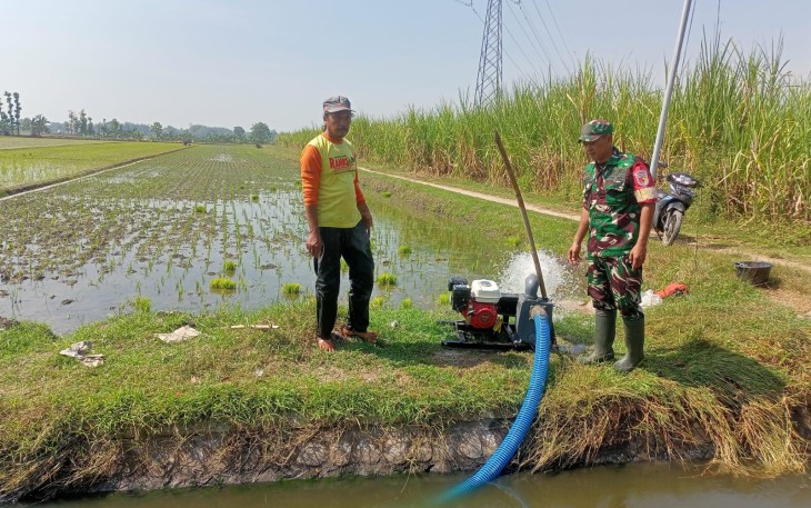 Babinsa Tiron Bantu Petani Alirkan Air ke Sawah