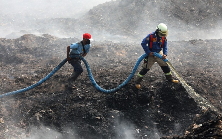 Personel gabungan berjibaku memadamkan api kebakaran TPA Jatiwaringin, Tangerang dengan menggunakan semprotan air pada Senin (6/7)