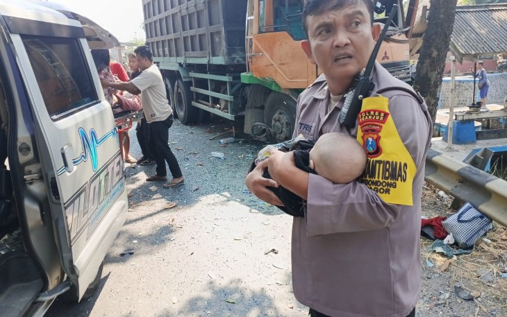 Aipda Sutrisno mengevakuasi bayi korban laka bus di Nganjuk