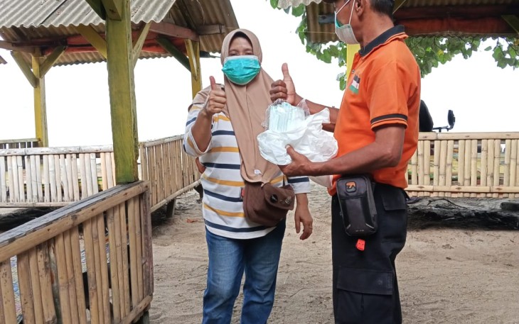 Personil BPBD Kabupaten Serang membagikan masker kepada masyarakat sebagai upaya perlindungan dari paparan abu vulkanik Gunung Anak Krakatau, Minggu (6/9). (Sumber: BPBD Kabupaten Serang)