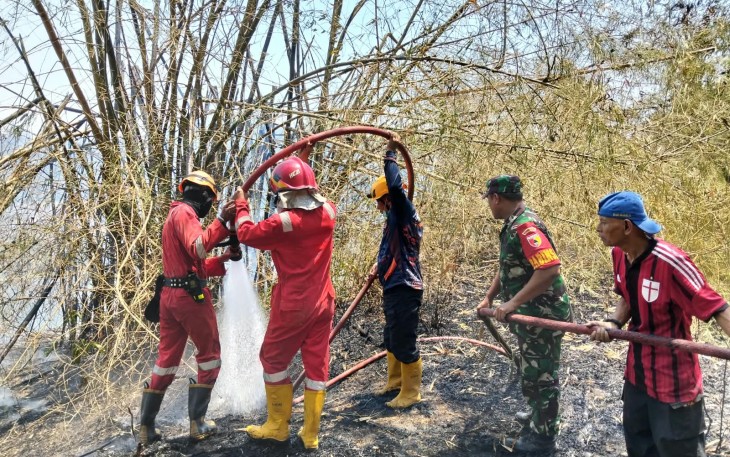 Babinsa dan Damkar Berjibaku Jinakkan Api di Lahan Bambu Nglames