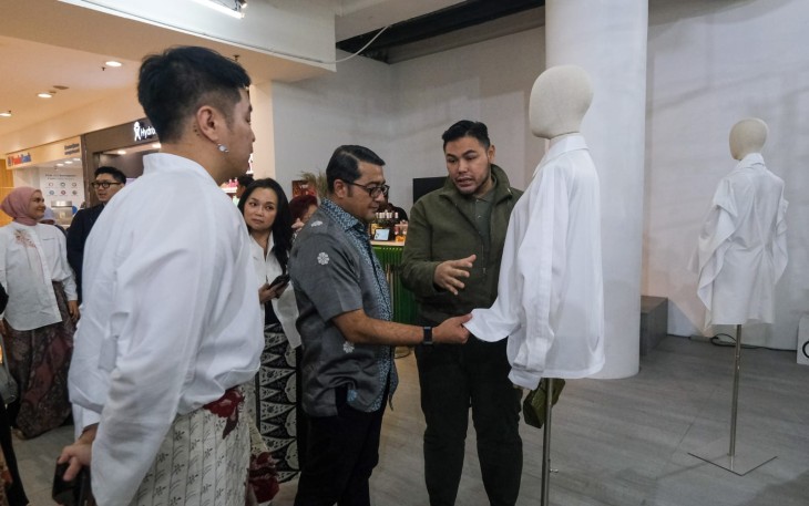 Menteri Ekonomi Kreatif/Kepala Badan Ekonomi Kreatif (Ekraf), Teuku Riefky Harsya (tengah), mendengarkan penjelasan mengenai busana dari perancang busana Ivan Gunawan (kanan) saat menghadiri pameran instalasi mode bertajuk “Gaya Archive Chapter 4” di Senayan City, Jakarta, Kamis (24/09/2026).