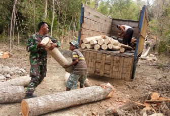 TNI dan Warga Pindahkan Batang Kayu