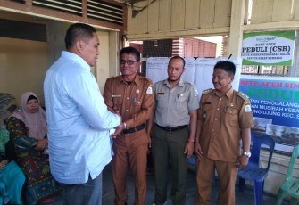 Bupati Aceh Singkil Dulmusrid saat menyerahkan bantuan korban kebakaran secara simbolis kepada Kepala Desa Ujung Singkil Jasruddin di Posko Kebakaran setempat.