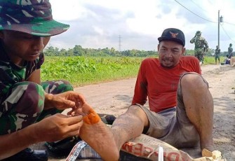 Praka Arif Wicaksono anggota Peleton Kesehatan dari Yonif 407 Padma Kusuma sedang memberikan pertolongan pertama kepada Drajat (60)