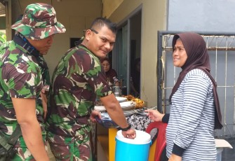 Ibu Aisyah Bantu menyajikan Makan Siang Satgas TMMD