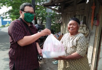 Pihak Baitul Maal Muhammadiyah Kottabarat Solo sedang menyalurkan paket sembako kepada warga.