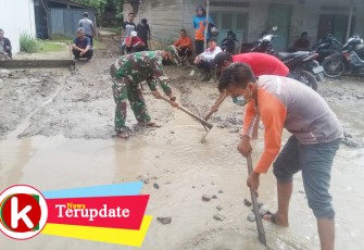 Babinsa turun langsung membuat aliran air yang menggenangi jalan
