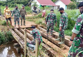 Personel TNI yang tergabung dalam Satgas Pamtas RI-MLY Yonif 407/PK, Pos Sei Beruang membantu memperbaiki jembatan yang rusak di Dusun Sei Beruang, Desa Sei Tekam, Kecamatan Sekayam, Kabupaten Sanggau, Kalbar. Senin (15/02/2021).