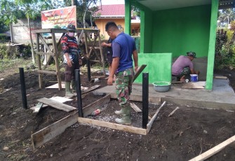 Satgas TMMD kodim Bitung saat memasang tiang pagar Poskamling