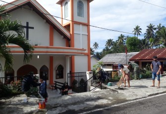 Warga bersama satgas TMMD kodim Bitung melakukan pembersihan area gereja katolik