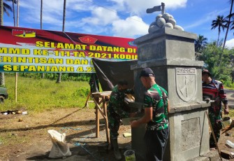 Personil satgas TMMD sedang mengerjakan pembuatan Tugu Prasasti TMMD