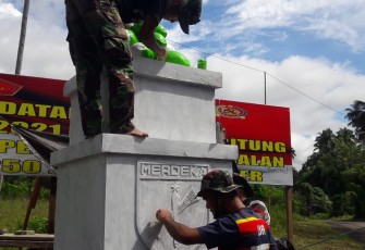Personil satgas TMMD saat melakukan pengecetan tugu prasasti