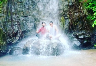 Kades Tanjung Kuaw dan salah satu anggota Tim Trip Klikwarta.com saat berada di bawah air terjun. Foto: Istimewa/Doc.klikwarta.com